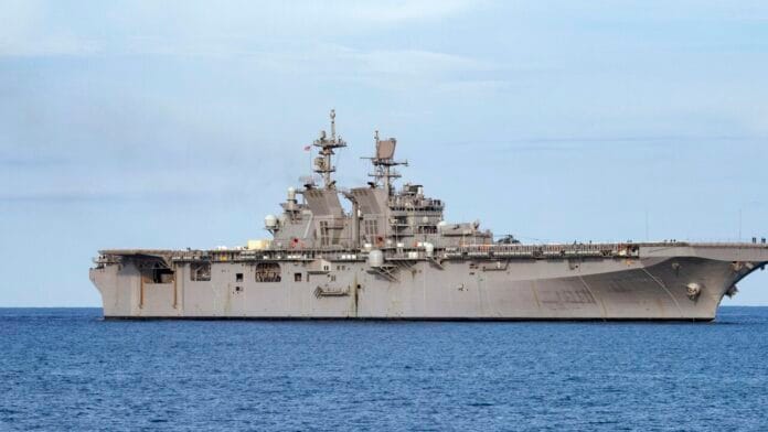 USS Tripoli sails during US naval operations, as part of Marine deployment readiness. USS Tripoli amphibious assault ship deploying US Marines to the Middle East