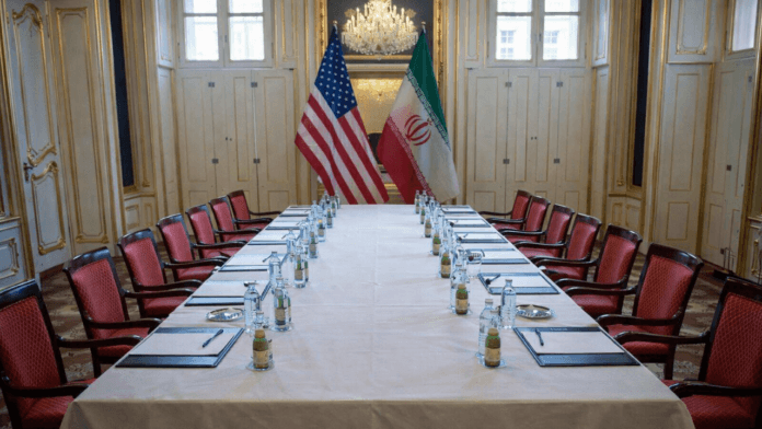 Empty negotiation table with US and Iran flags symbolizing suspended diplomatic talks